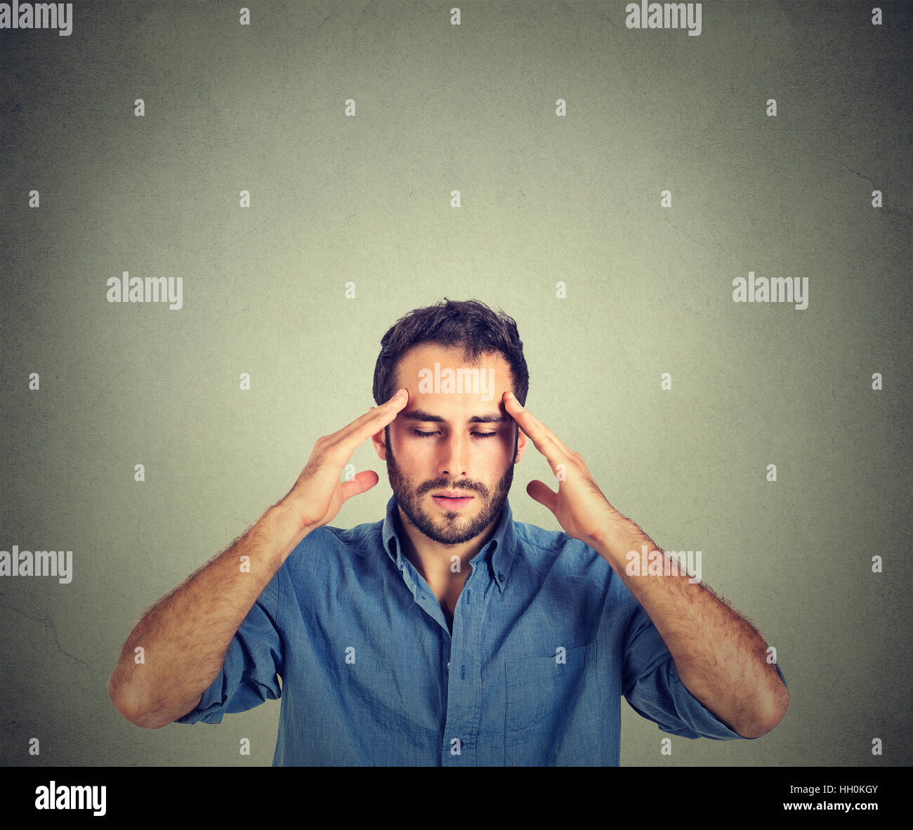 Stressed man thinking very intensely concentrating isolated on gray wall background Stock Photo