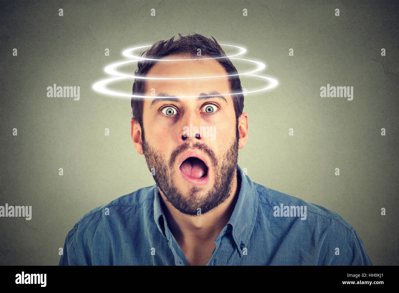 Head is spinning. Surprise astonished man. man looking surprised in disbelief wide open mouth isolated on gray background. Stock Photo