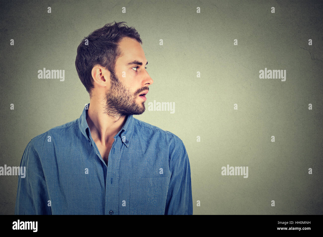 Profile view of sad young man looking down Stock Photo - Alamy