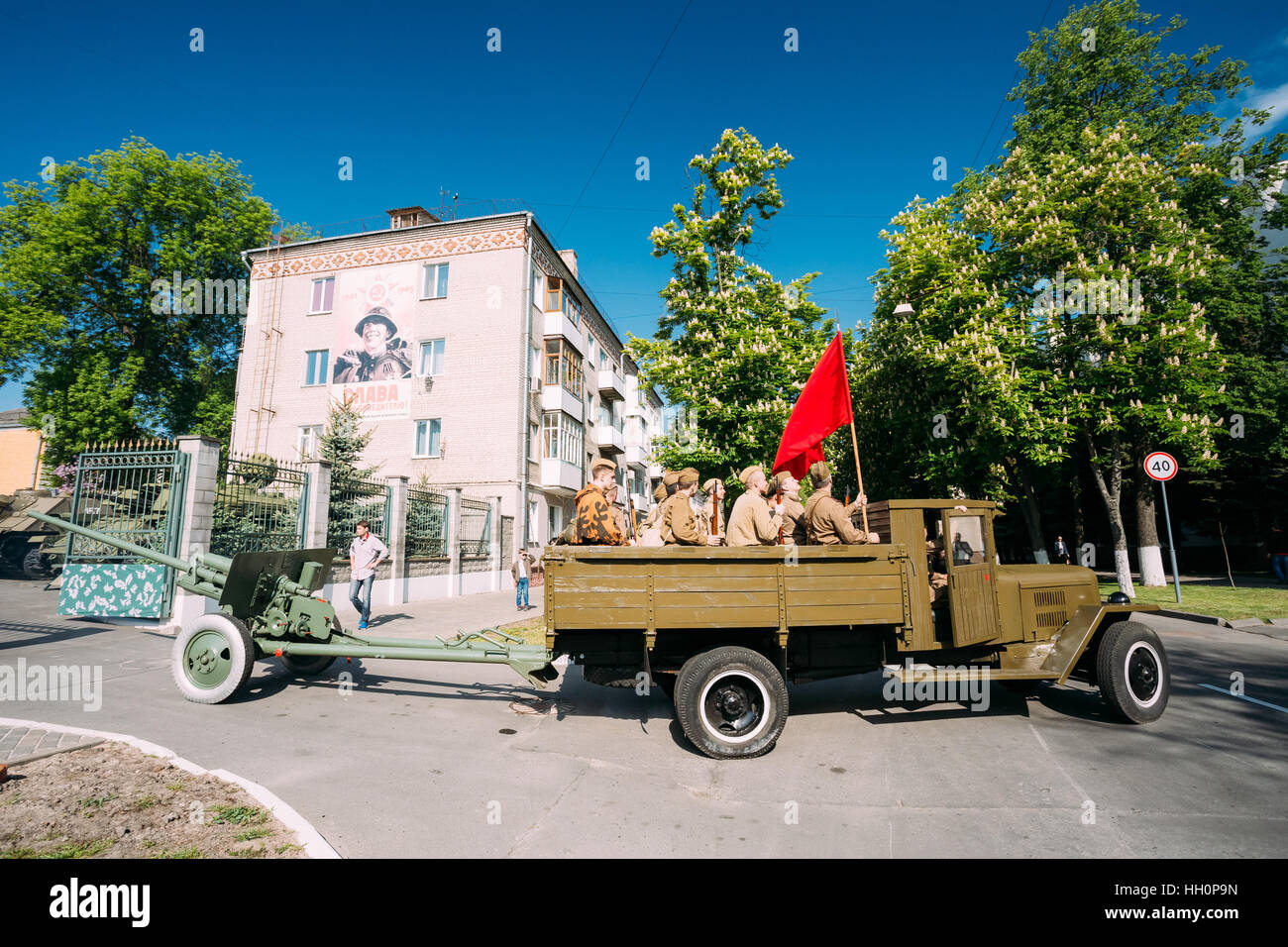 Gomel, Belarus  - May 9, 2016: Russian Soviet Military Truck ZIS-5V With Men In Soldiers Uniform On Board, Weapon, Red Flag Of WW2, Towing ZiS-2 57-Mm Stock Photo