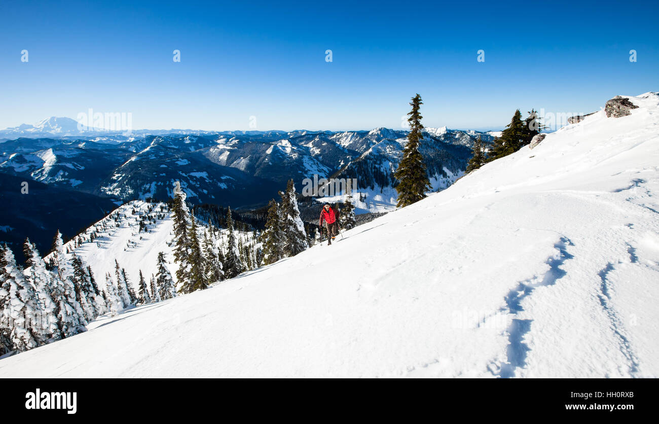 A man snowshoeing up a mountain in the North Cascades Mountains of