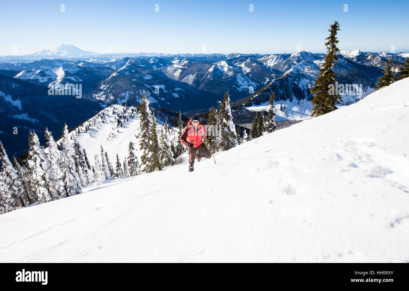 A man snowshoeing up a mountain in the North Cascades Mountains of