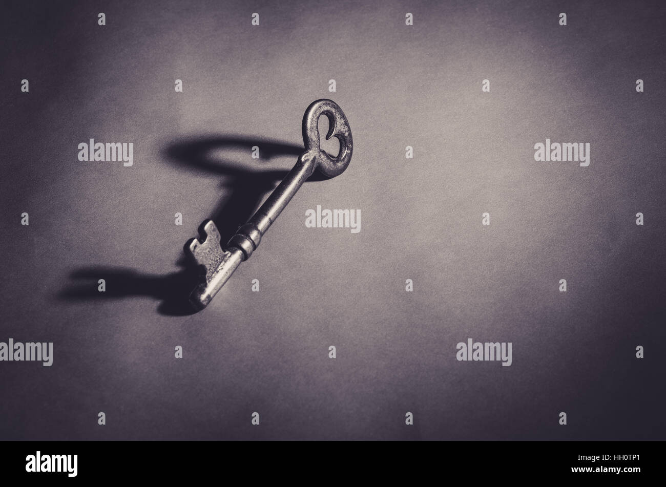 A skeleton key with a heart with shadow in black and white. Stock Photo