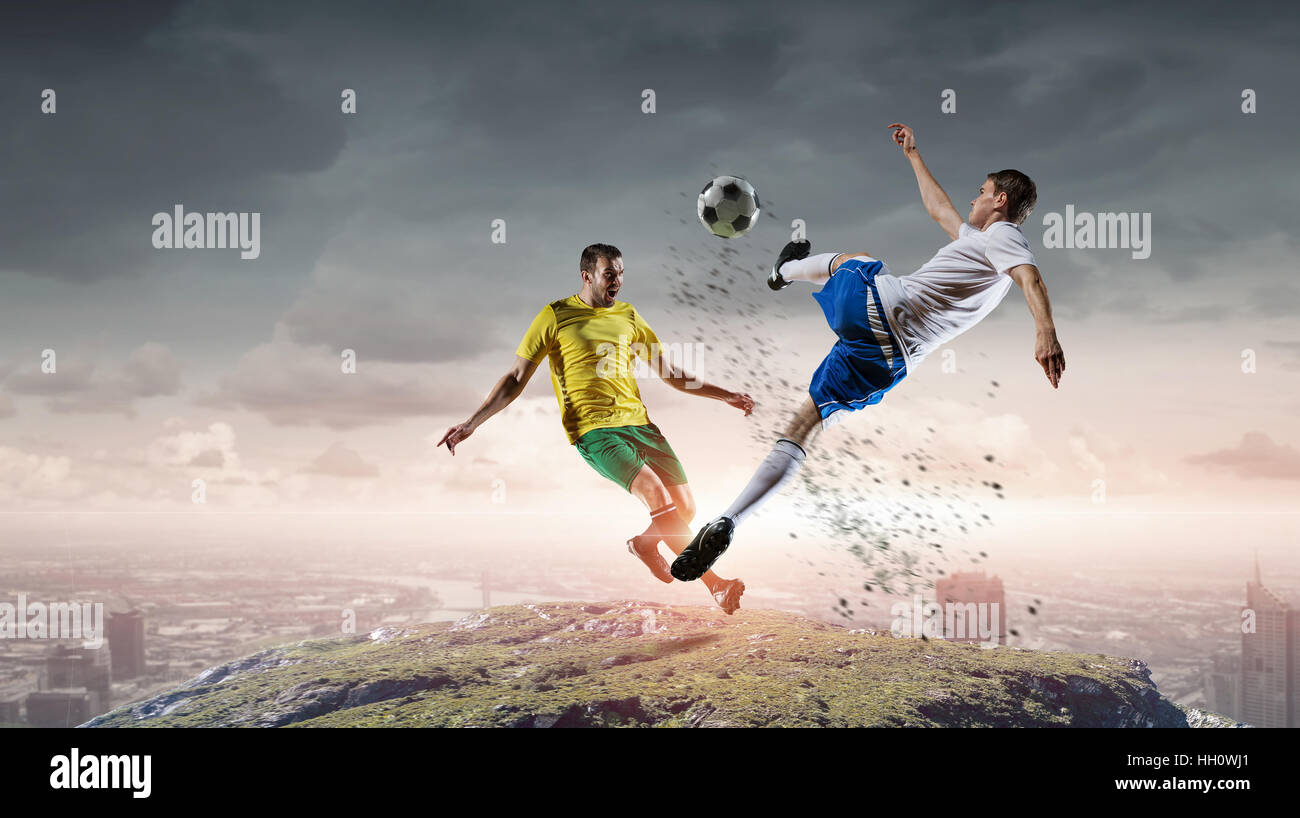 Soccer player with ball in action at natural landscape Stock Photo