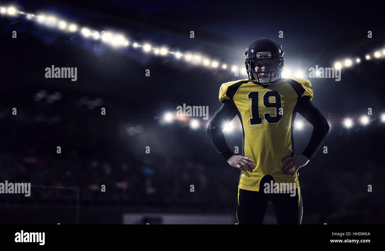 Confident American football player in lights of sport arena. Mixed media Stock Photo