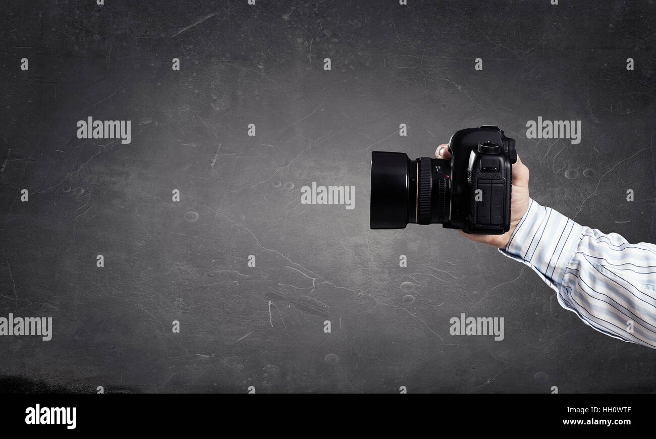 Close of man hand in shirt holding photocamera Stock Photo