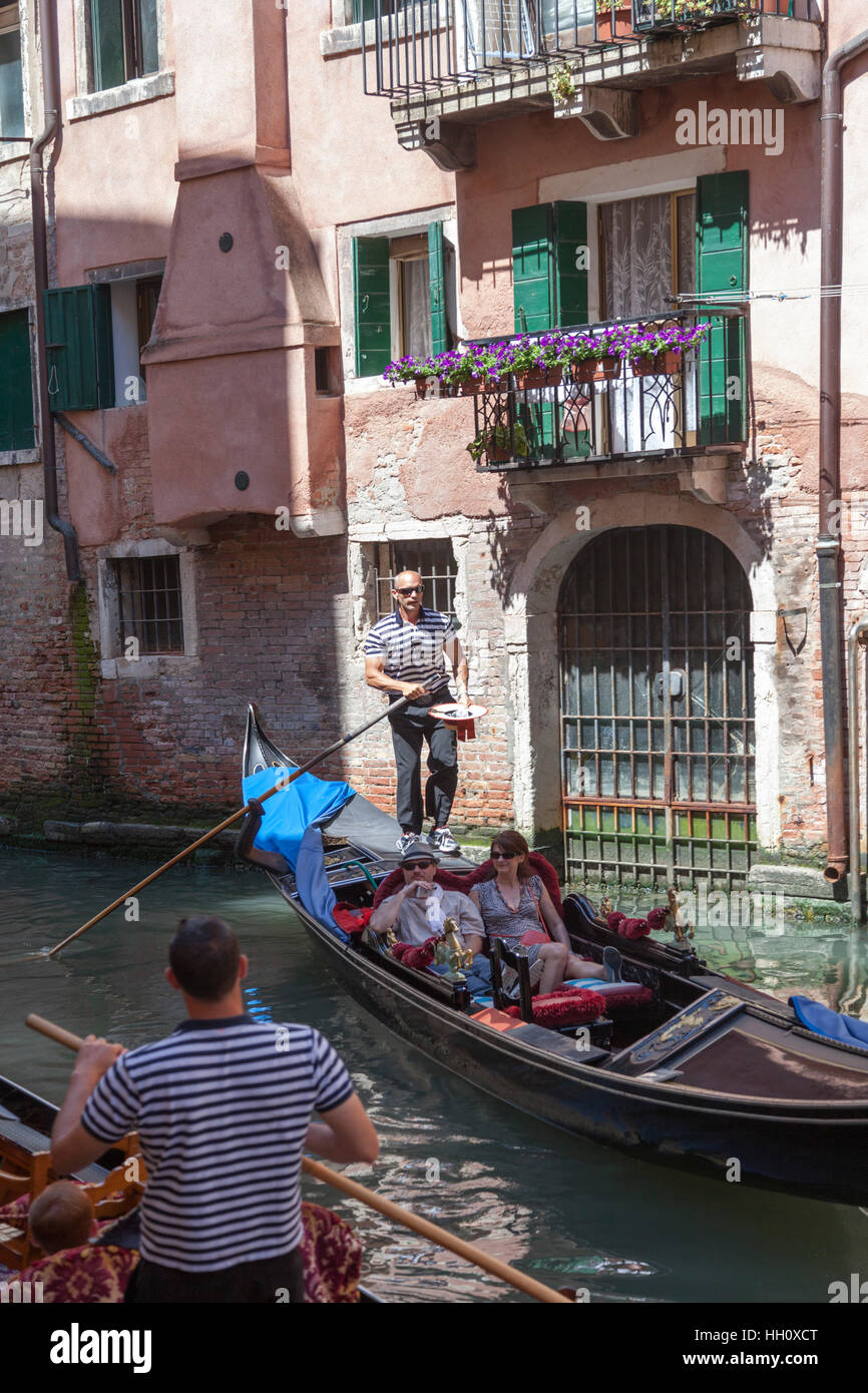 High-angle shot on a gondola from the vantage point of a Venetian bridge (Venice - Italy). A typical Venetian scene. Stock Photo