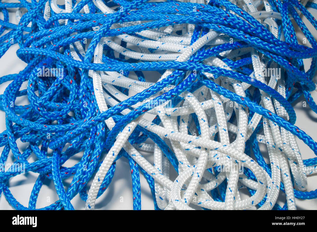 Tangled pile of blue and white plait ropes Stock Photo