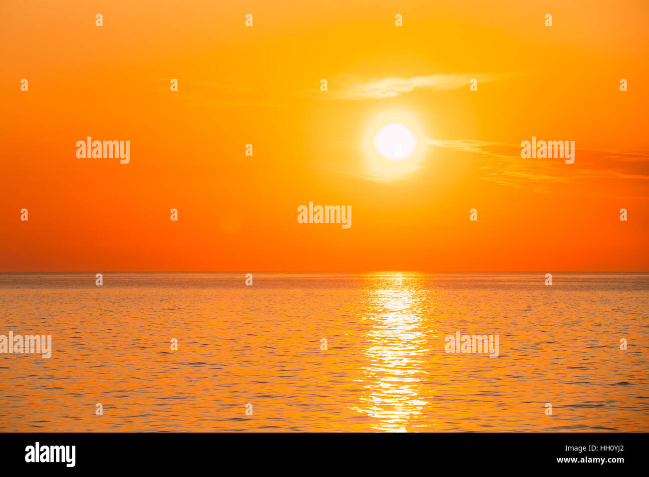 Sun Is Setting On Horizon At Sunset Sunrise Over Sea Or Ocean. Tranquil Sea Ocean Waves. Natural Sky Warm Colors. Stock Photo