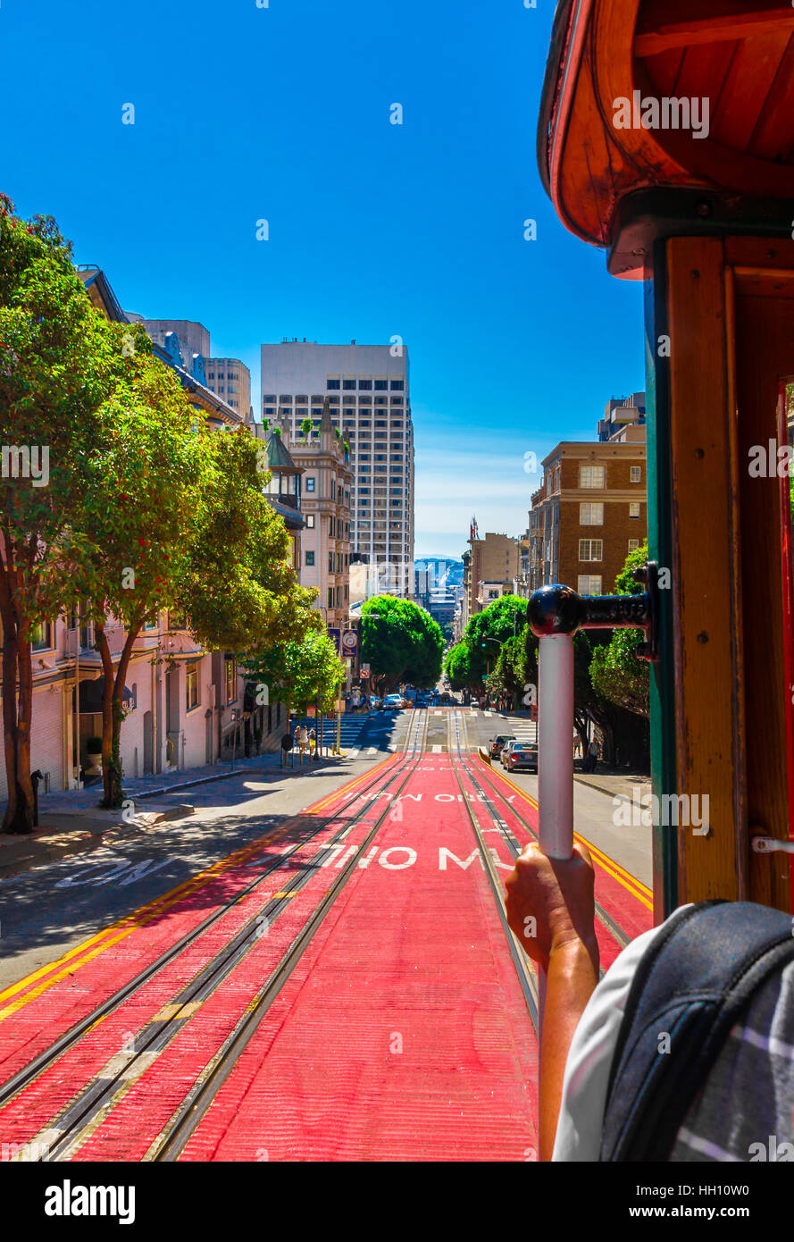 Ride with the cable car in San Francisco. The picture shows a person riding on the famous MUNI train on Powell-Mason line down the hill of Powell Stre Stock Photo