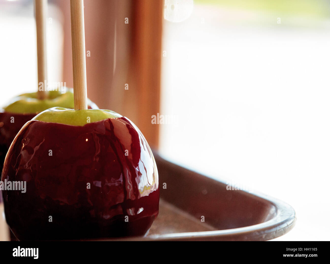 Candy apples with caramel and nuts on a stick in a candy store window