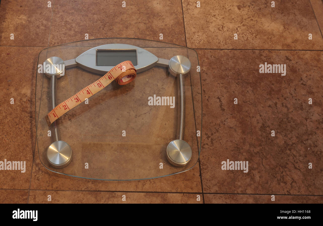 Scale to monitor weight with a measuring tape to take measurements to keep track of physical fitness Stock Photo