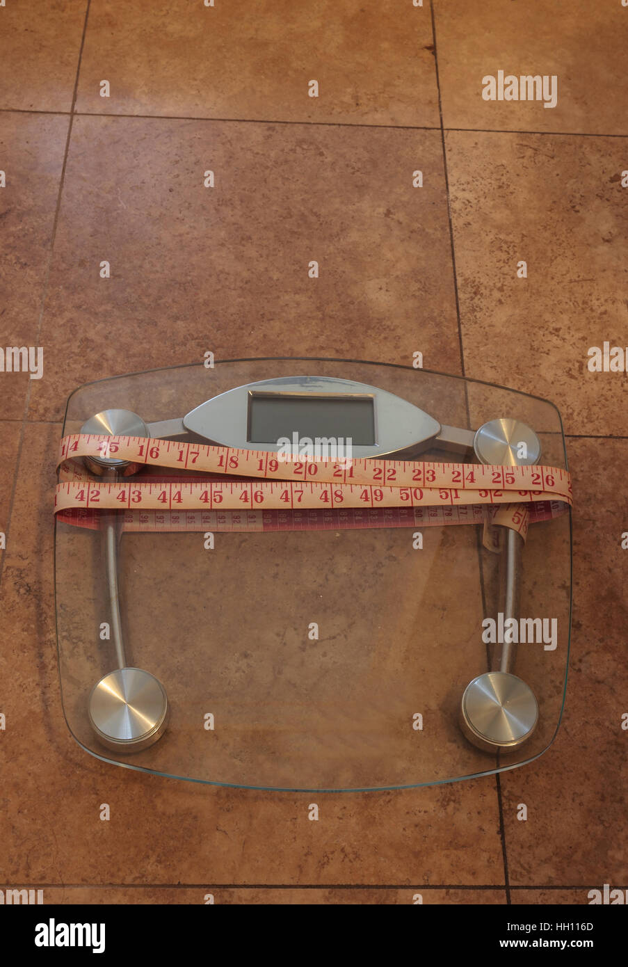 Scale to monitor weight with a measuring tape to take measurements to keep track of physical fitness Stock Photo