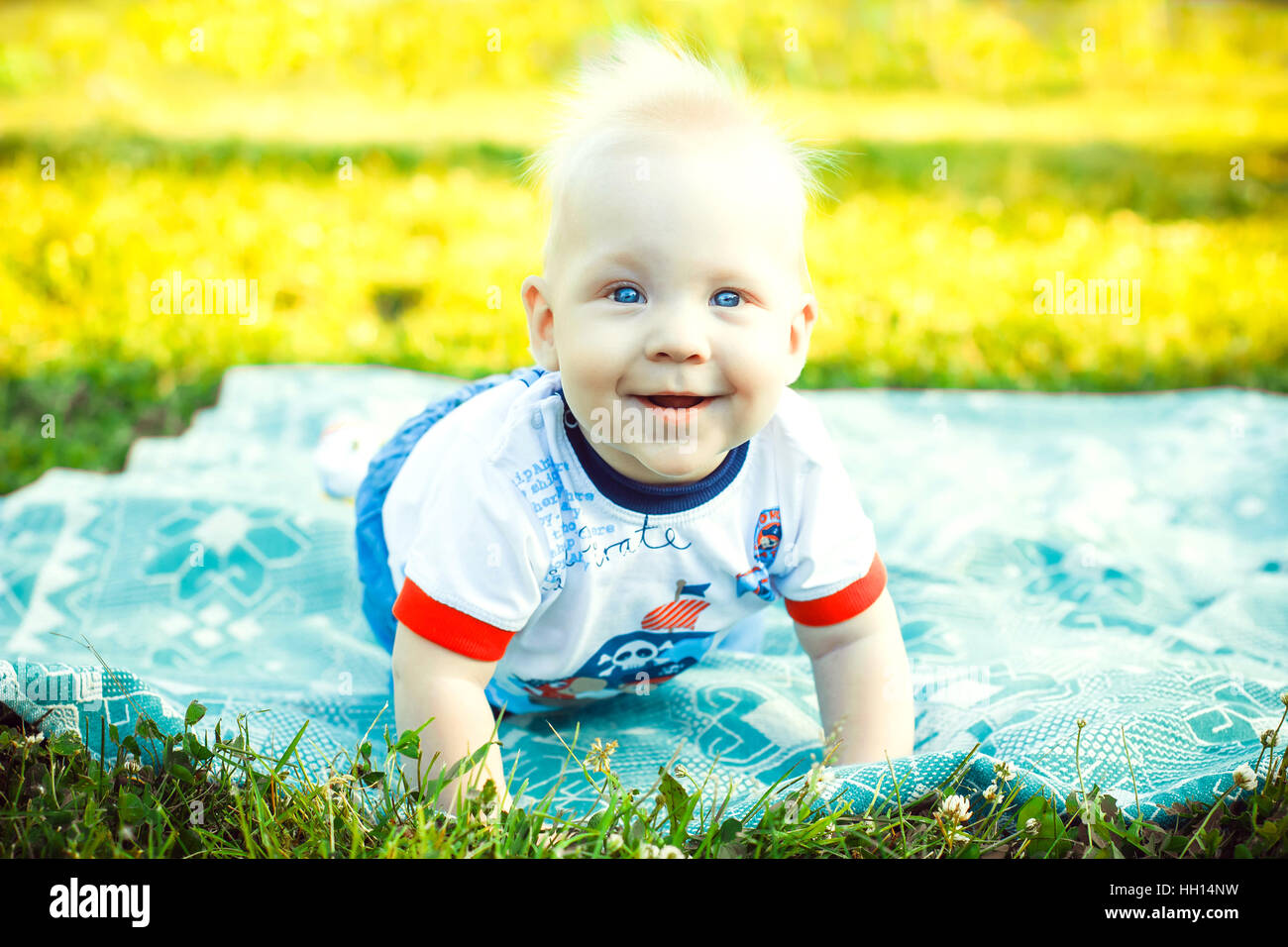 baby smiling and crawling on lawn Stock Photo - Alamy