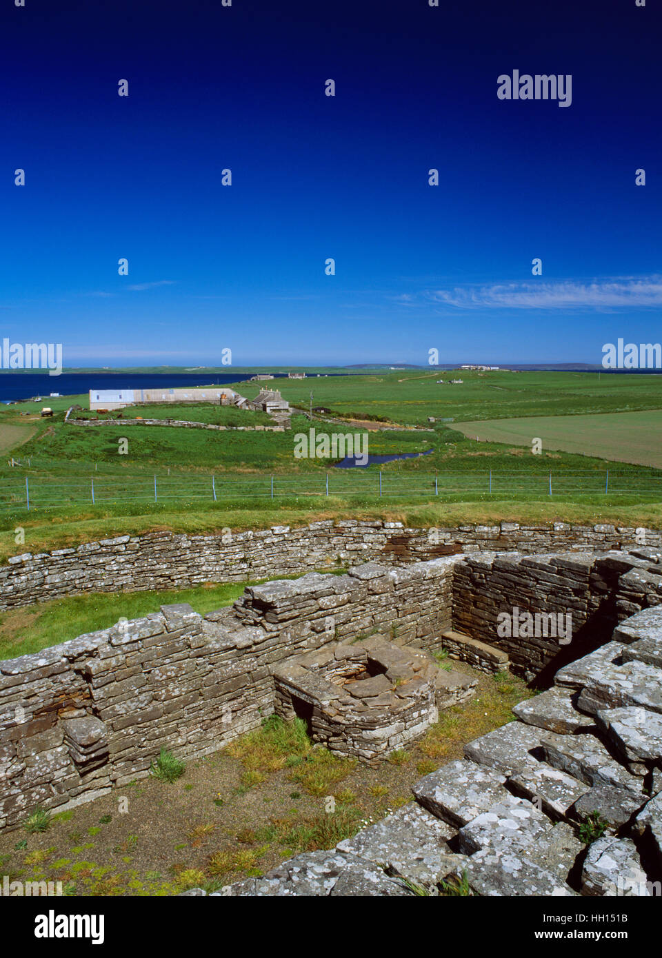 View NE from the keep of Cubbie Roo's Castle, over an outbuilding with an oven, to the Bu of Wyre farm & Egilsay island, Orkney. Stock Photo