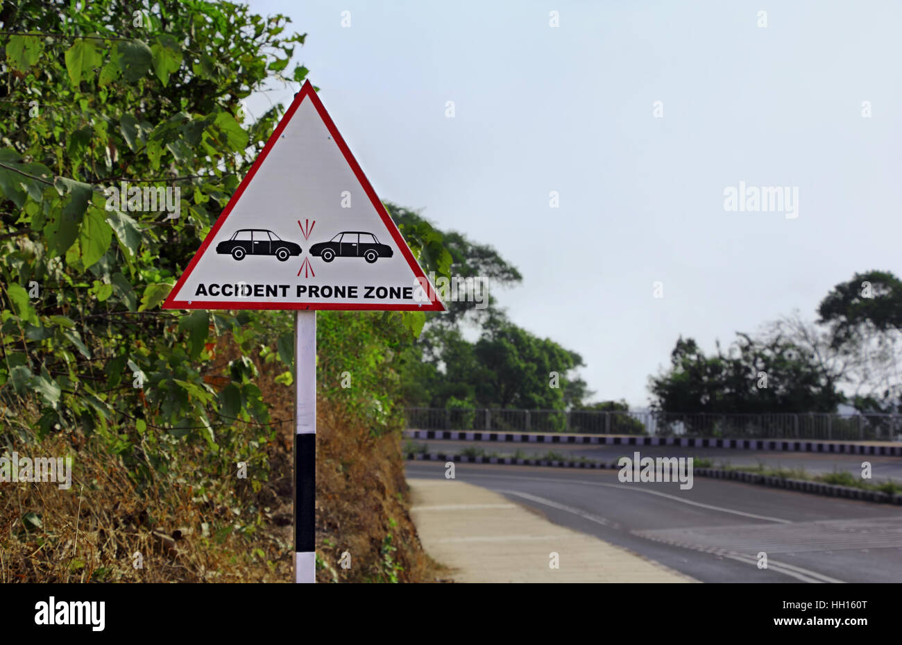 Road sign warning motorists to be careful at a zone prone to possible accidents and collisions in a hill highway Stock Photo