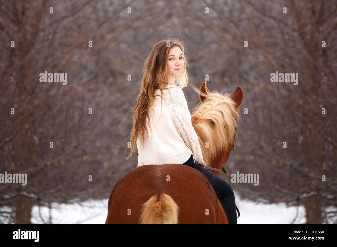 Cute girl riding horse looking back over shoulder Stock Photo
