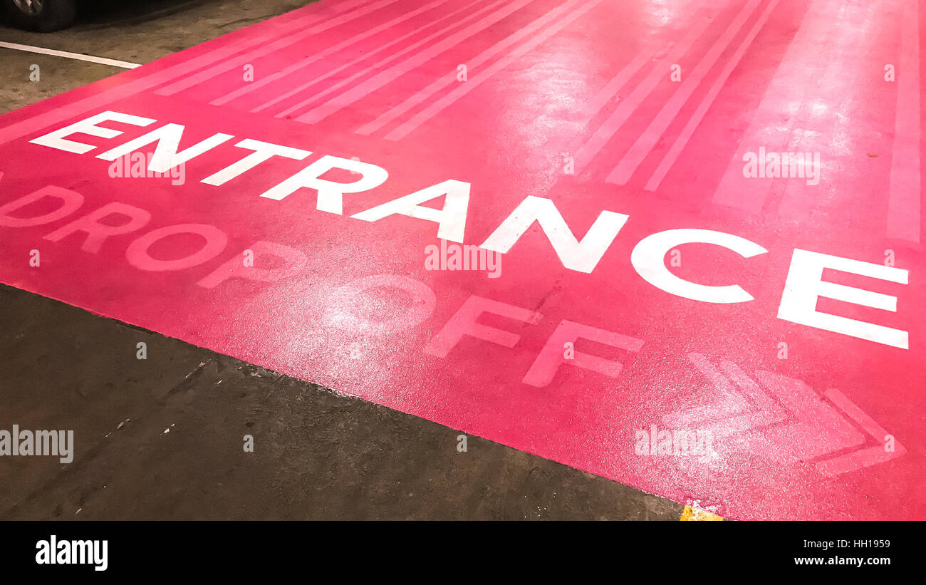 Entrance text and drop off sign on pink floor Stock Photo Alamy