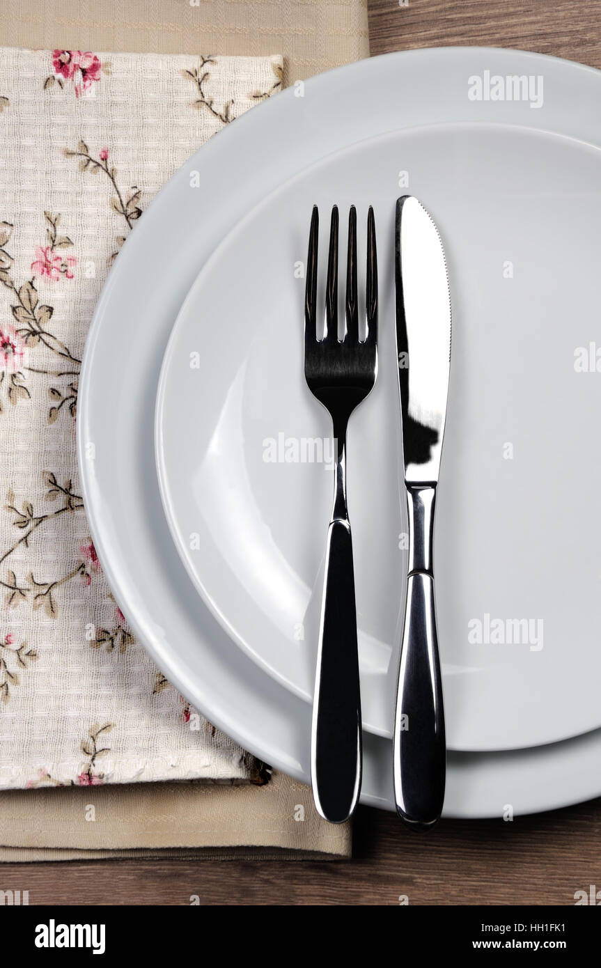 Dining etiquette - I still eat, finished. Fork and knife signals with location of cutlery set. Stock Photo