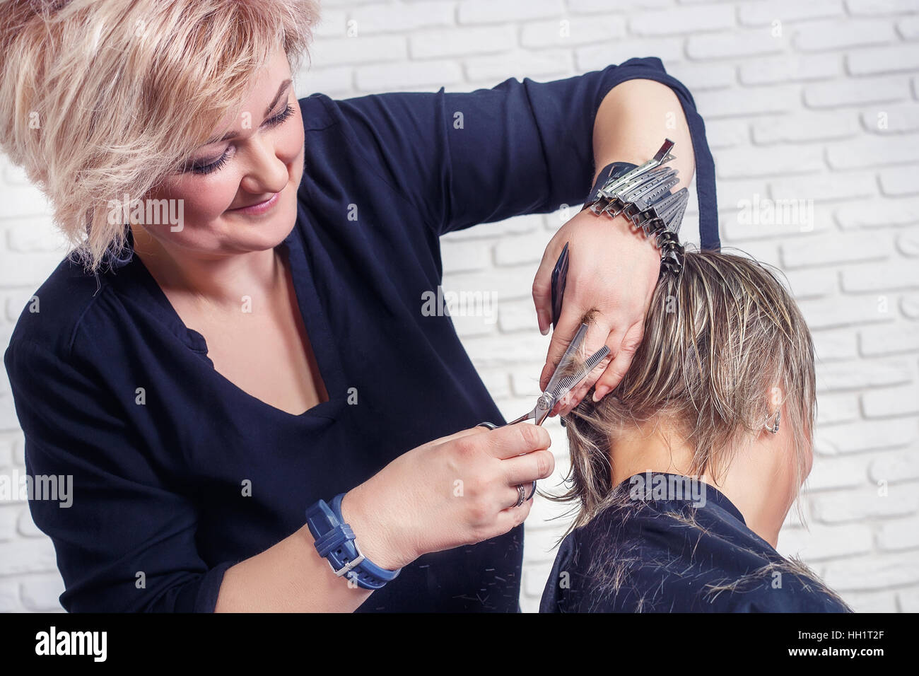 Hairdresser cutting hair with scissors Stock Photo