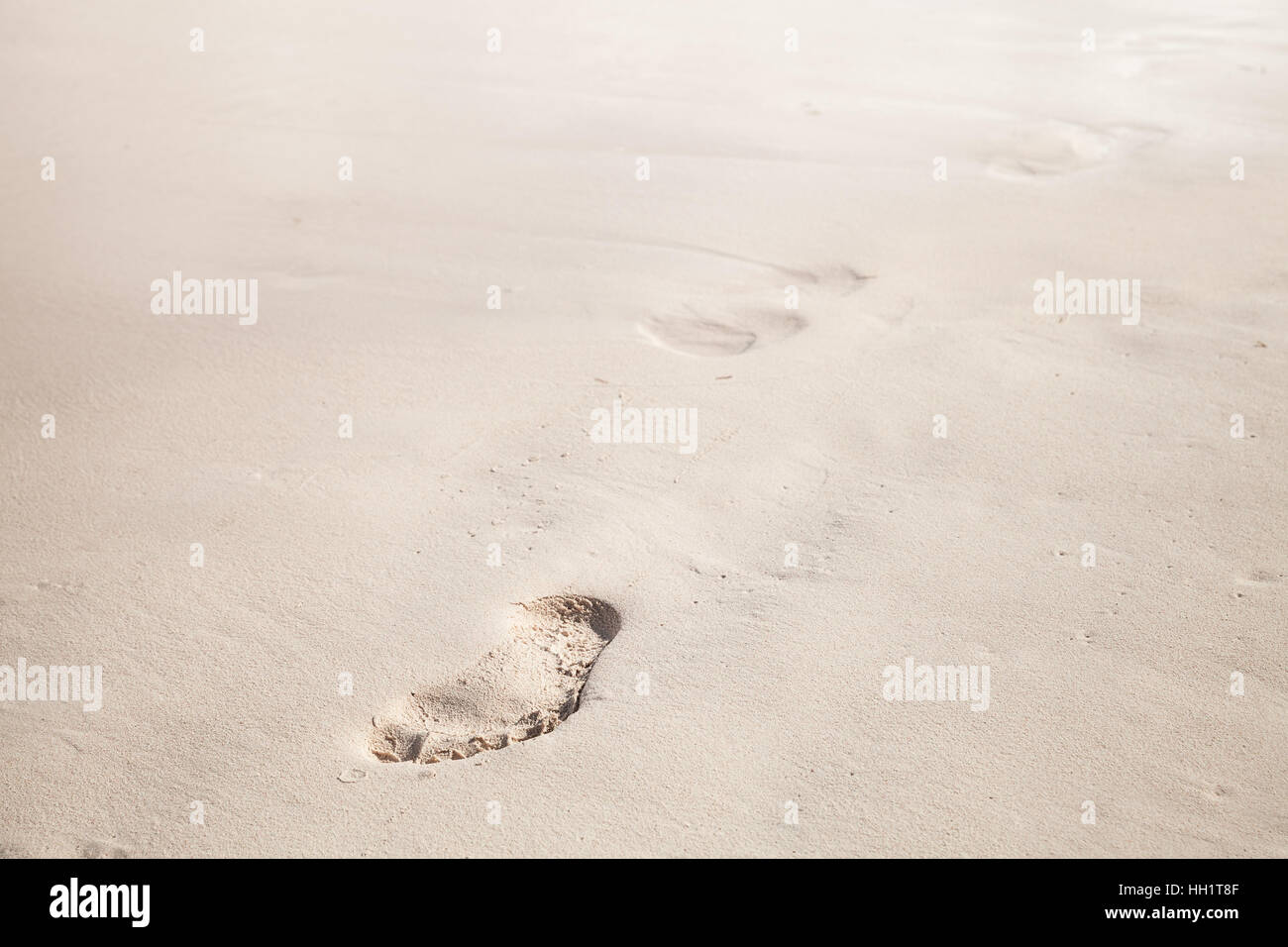 Footprints in white coastal sand, ocean beach background photo Stock Photo