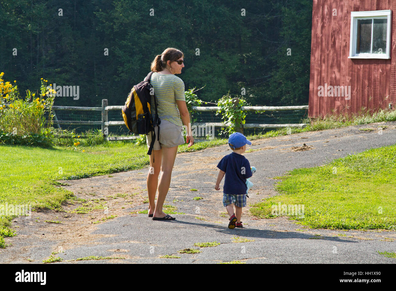 A mother with her son walking back to the barn on a summer day Stock Photo
