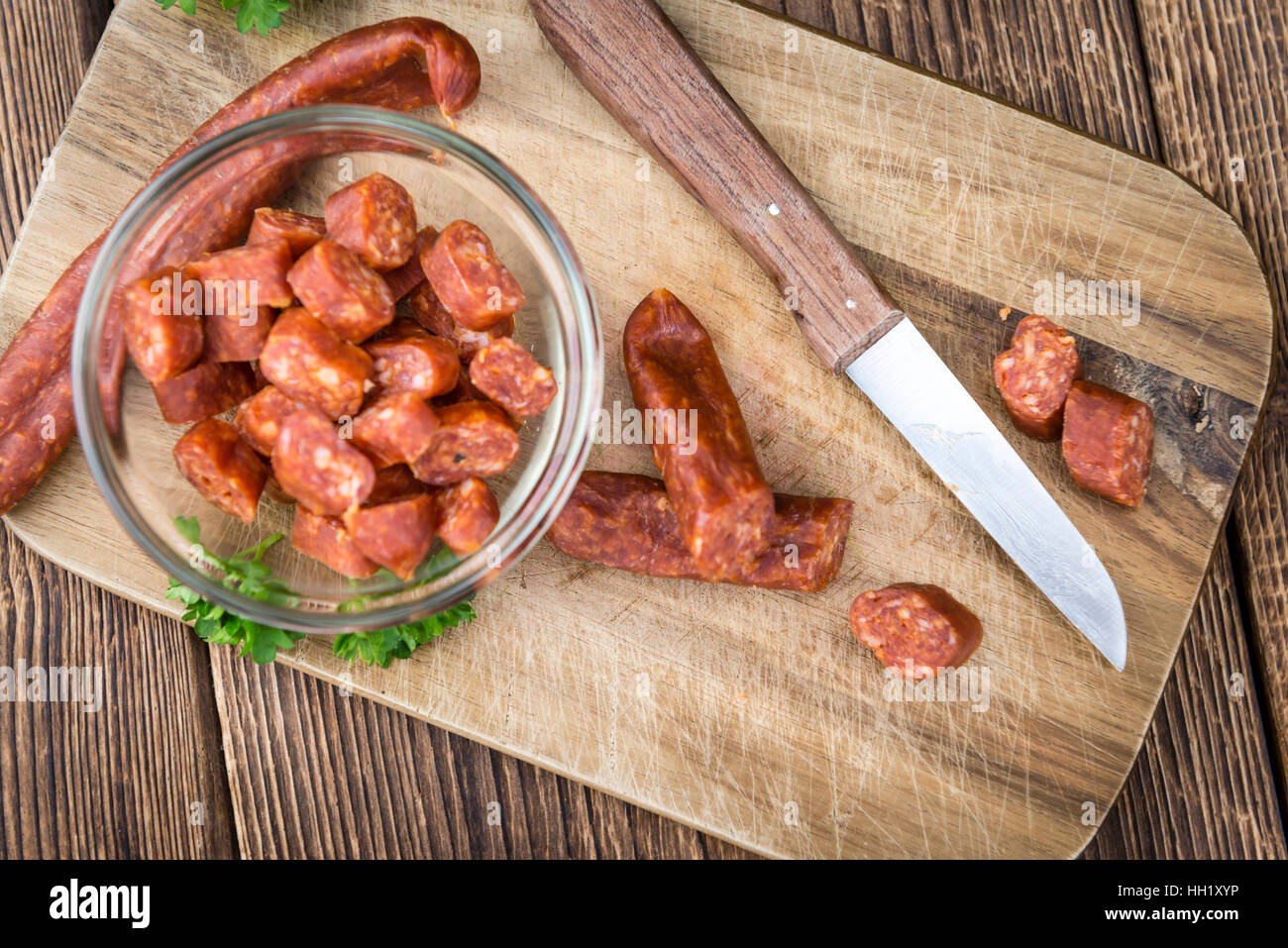 Chilli flavoured Sausages (German Mettwurst) on wooden background (selective focus) Stock Photo