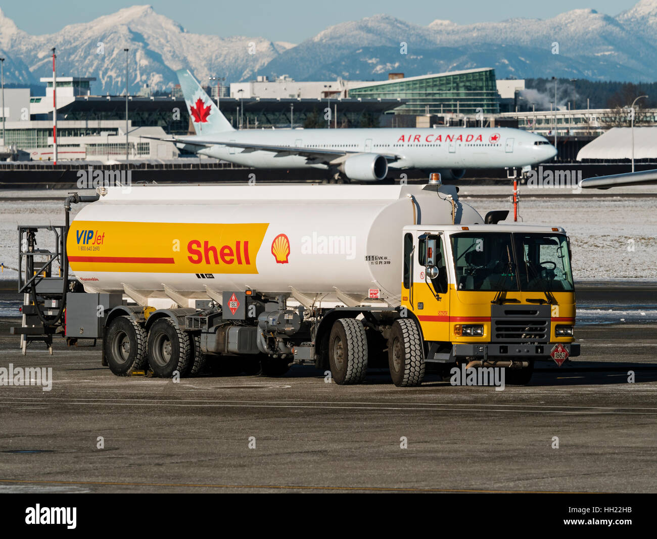 A Shell Aviation fuel tanker truck on the tarmac at Vancouver International Airport, Richmond, B.C., January 4, 2017. In the background an Air Canada  Stock Photo