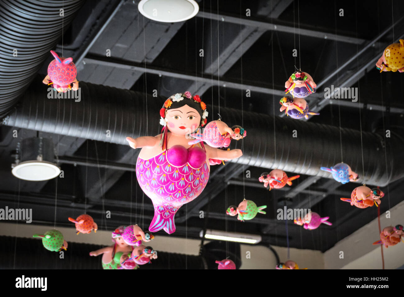 Photograph of some toy fat mermaids hanging,from the roof Stock Photo