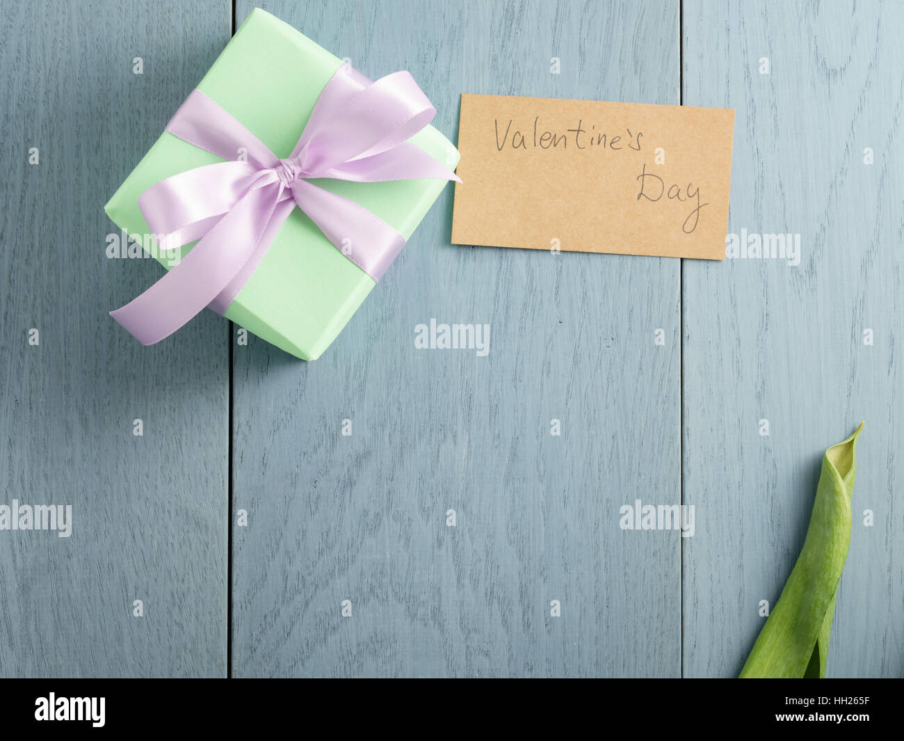 green gift box on blue wood table with paper card for valentines day Stock Photo