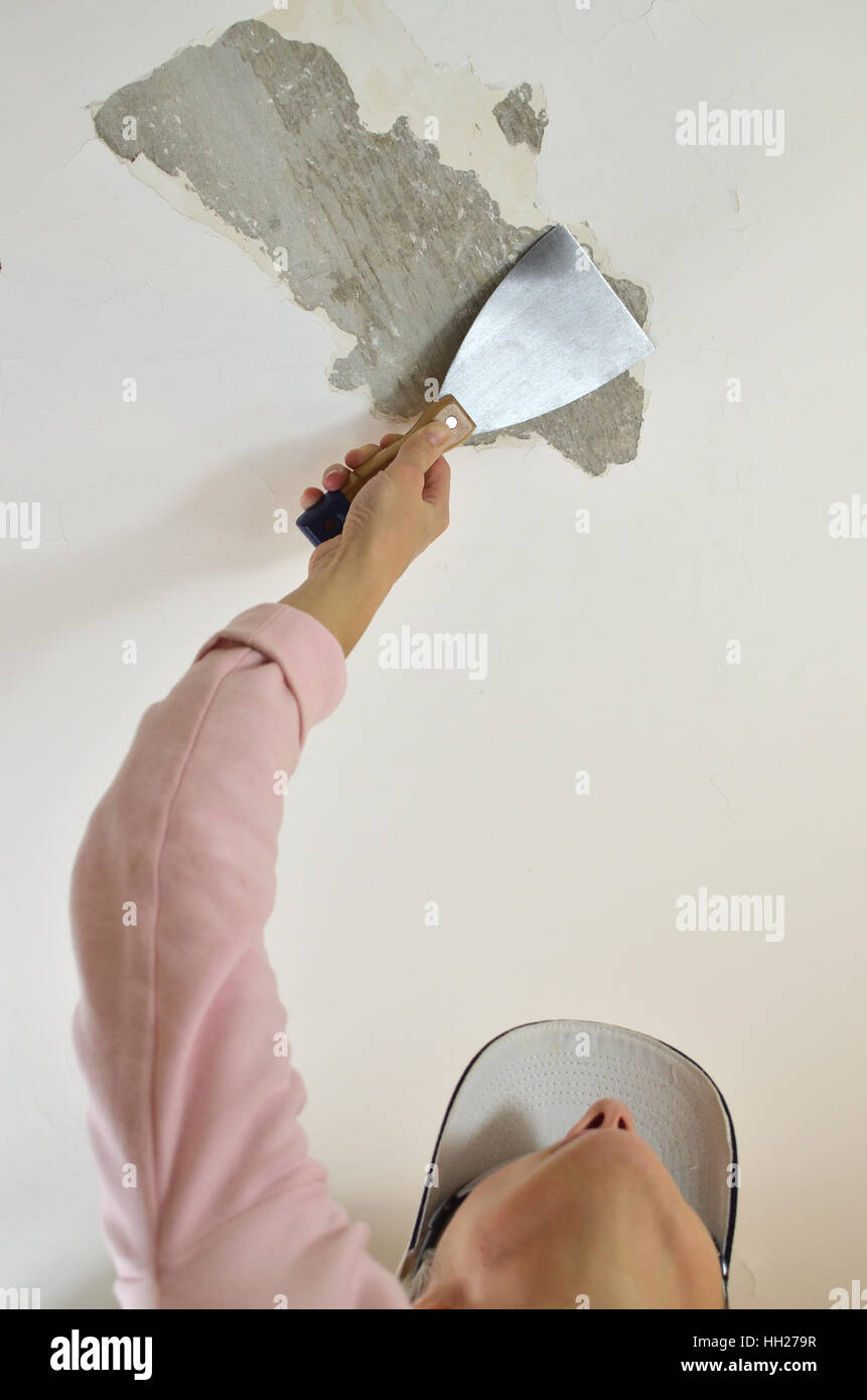 Hand Holding A Plaster Spatula Peeling A Ceiling Preparing