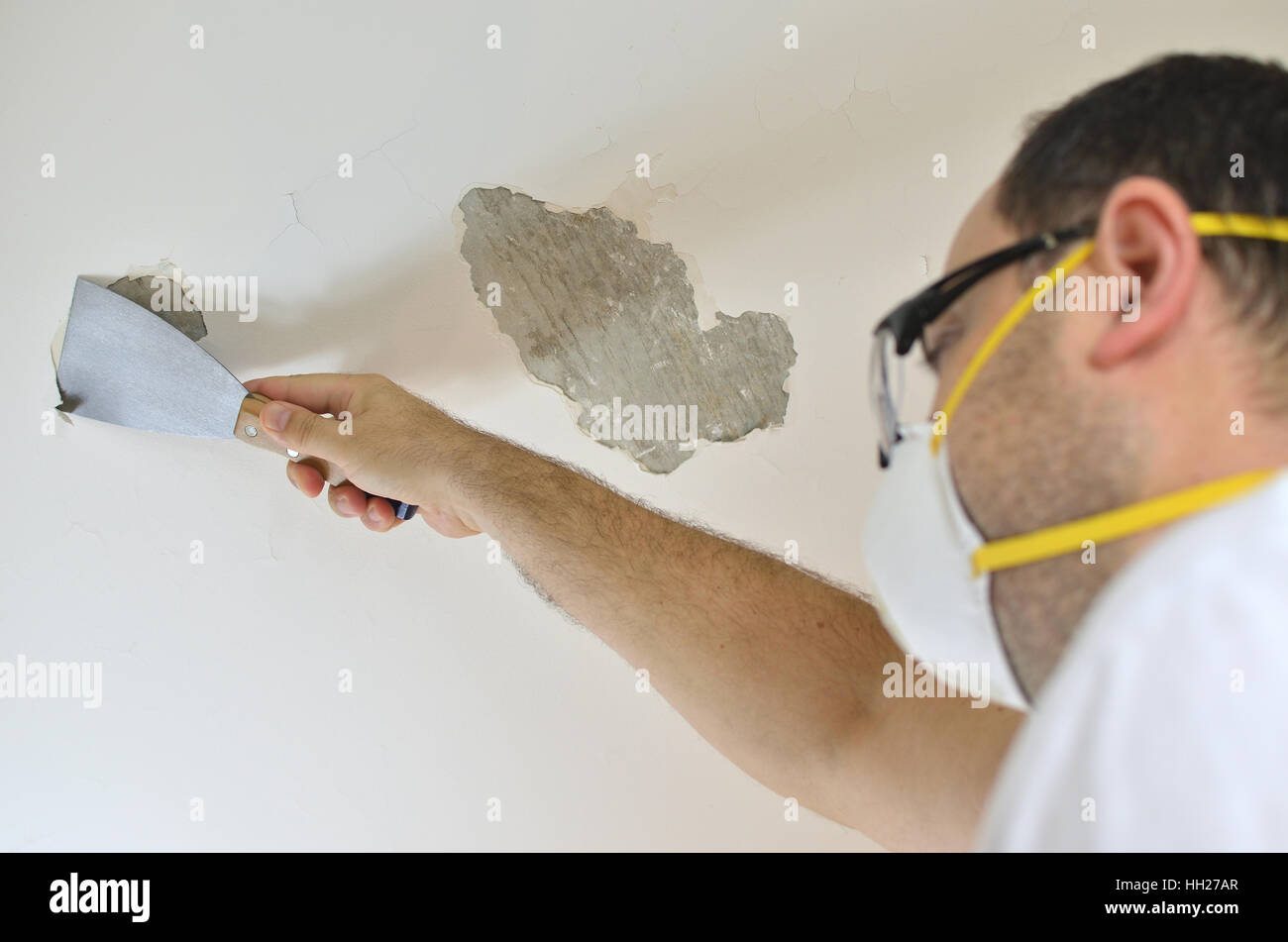 Man Holding A Plaster Spatula Peeling A Ceiling Preparing It For