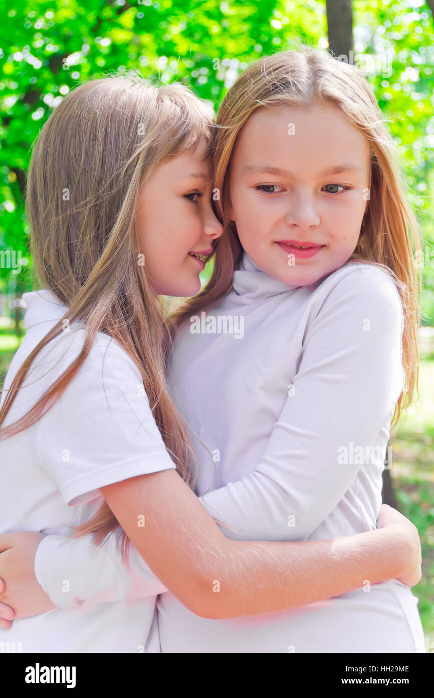 Photo of two smiling whispering girls in summer Stock Photo - Alamy