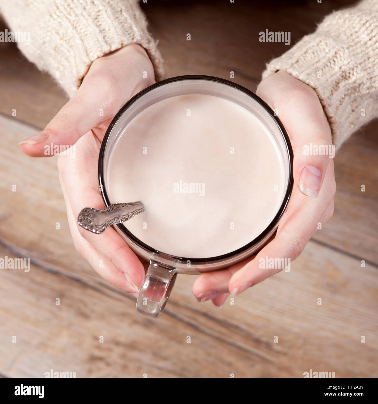 Hands in mittens hold cocoa. Face in unfocus Stock Photo