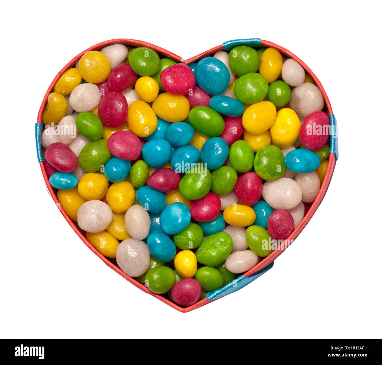 Heart-shaped box filled with colorful candies isolated on white Stock Photo