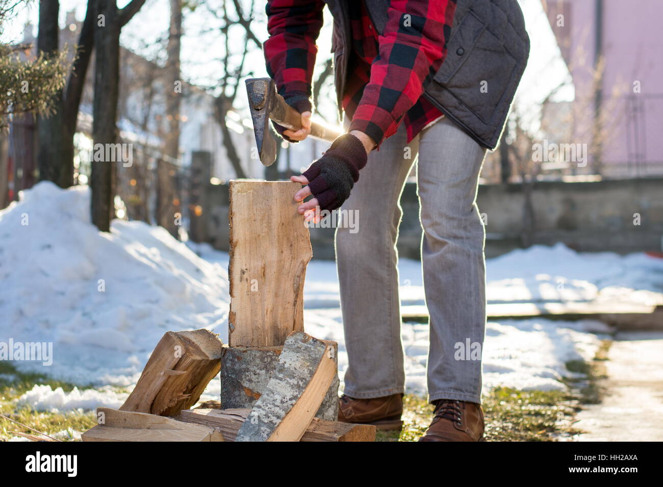 Man chopping firewood in the front yard Stock Photo