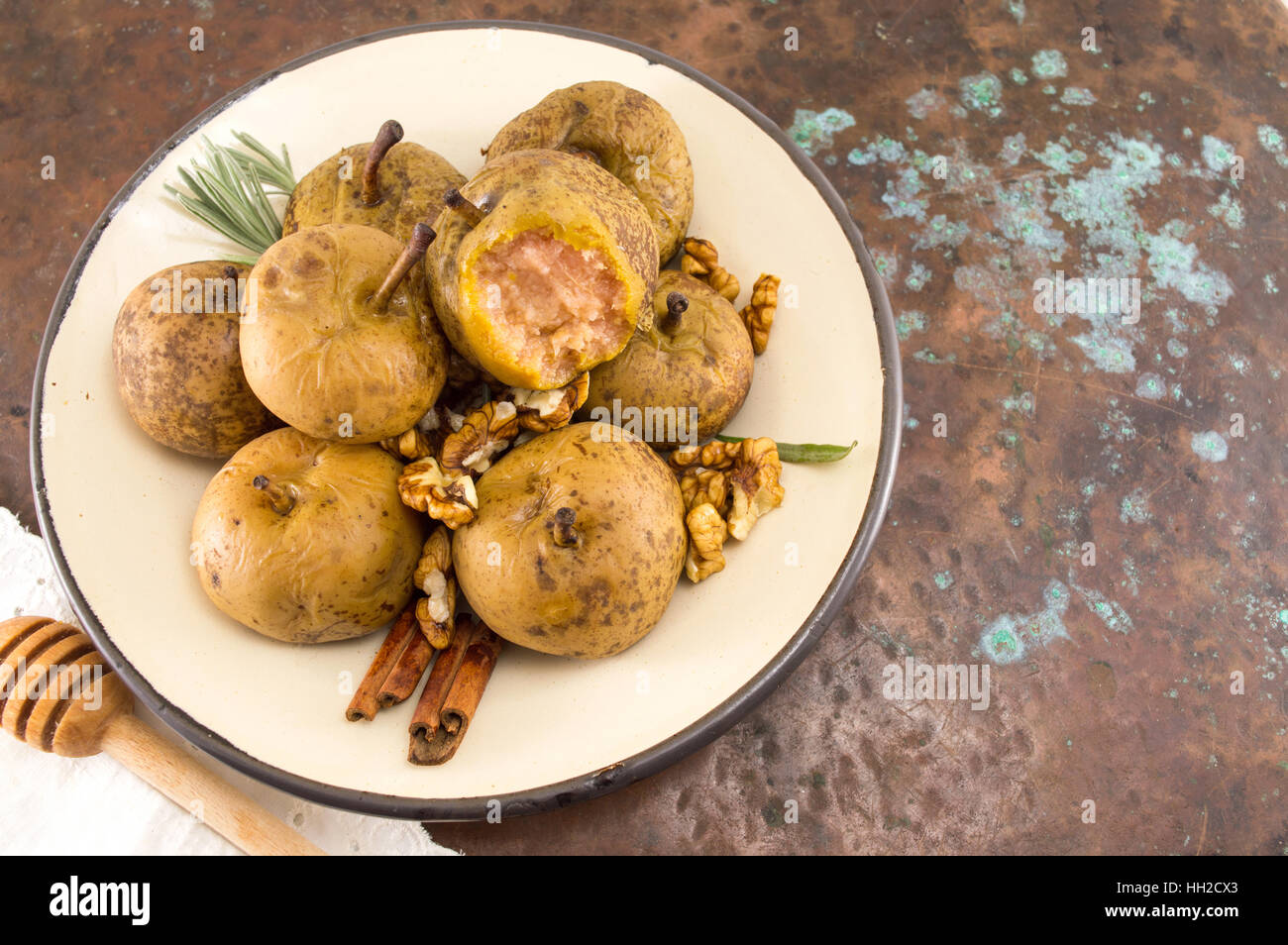 boiled wild pears with walnuts and cinnamon on a plate Stock Photo