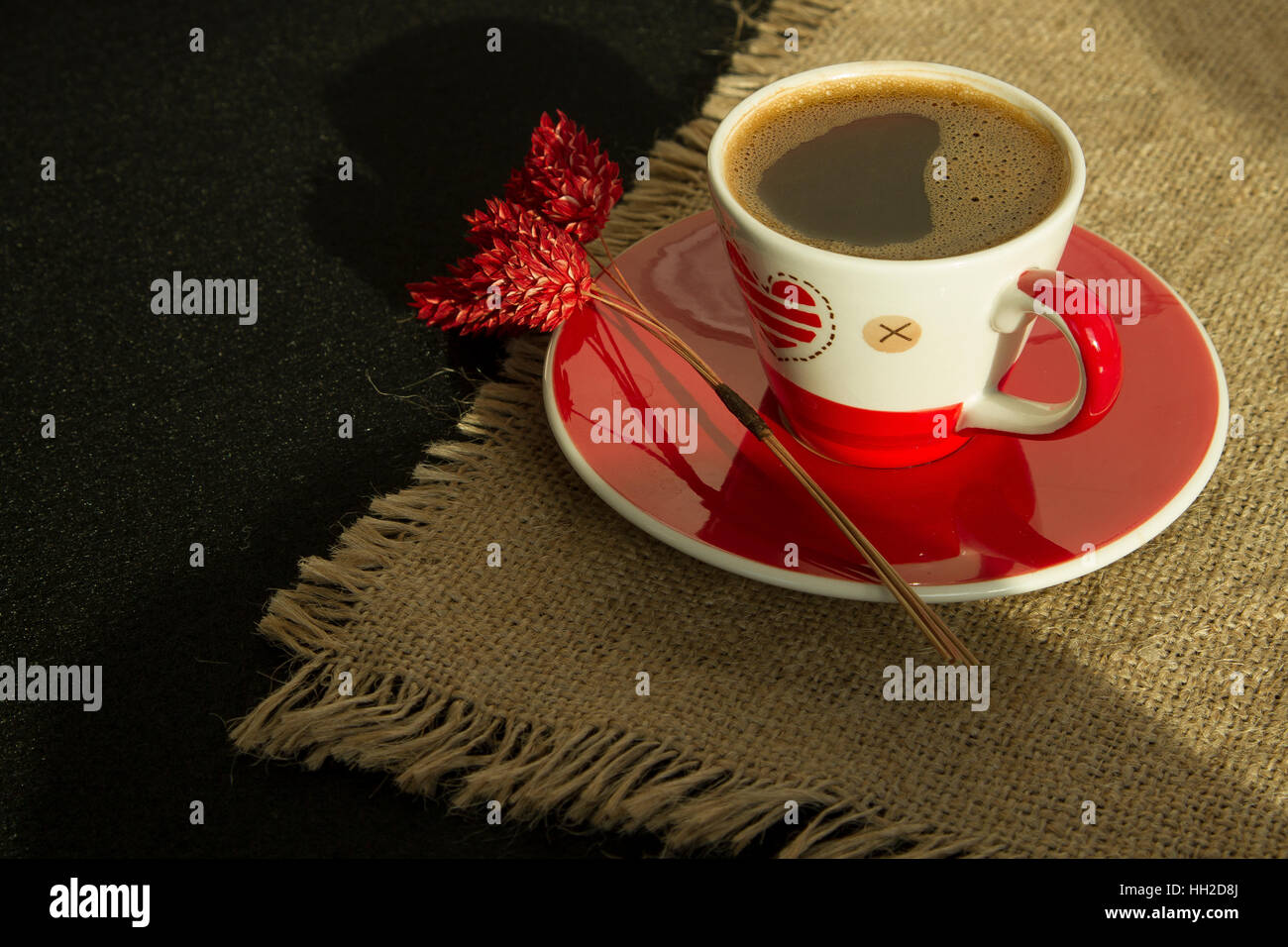 Red cup of coffee with flower on linen cloth Stock Photo
