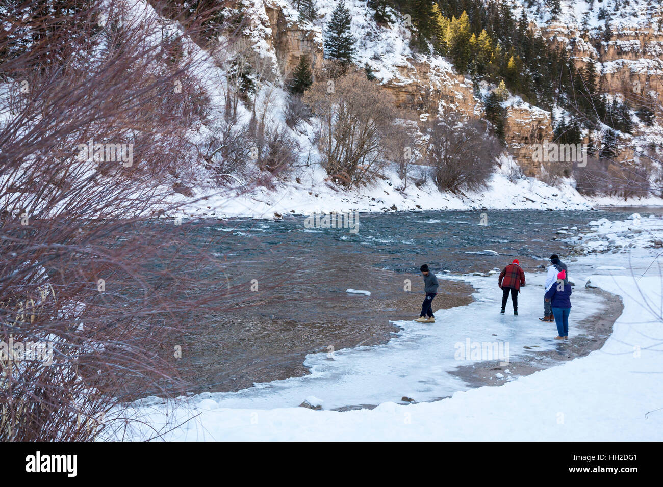 Glenwood Springs, Colorado - Visitors walk on the winter ice at the edge of the Colorado River in Glenwood Canyon. Stock Photo