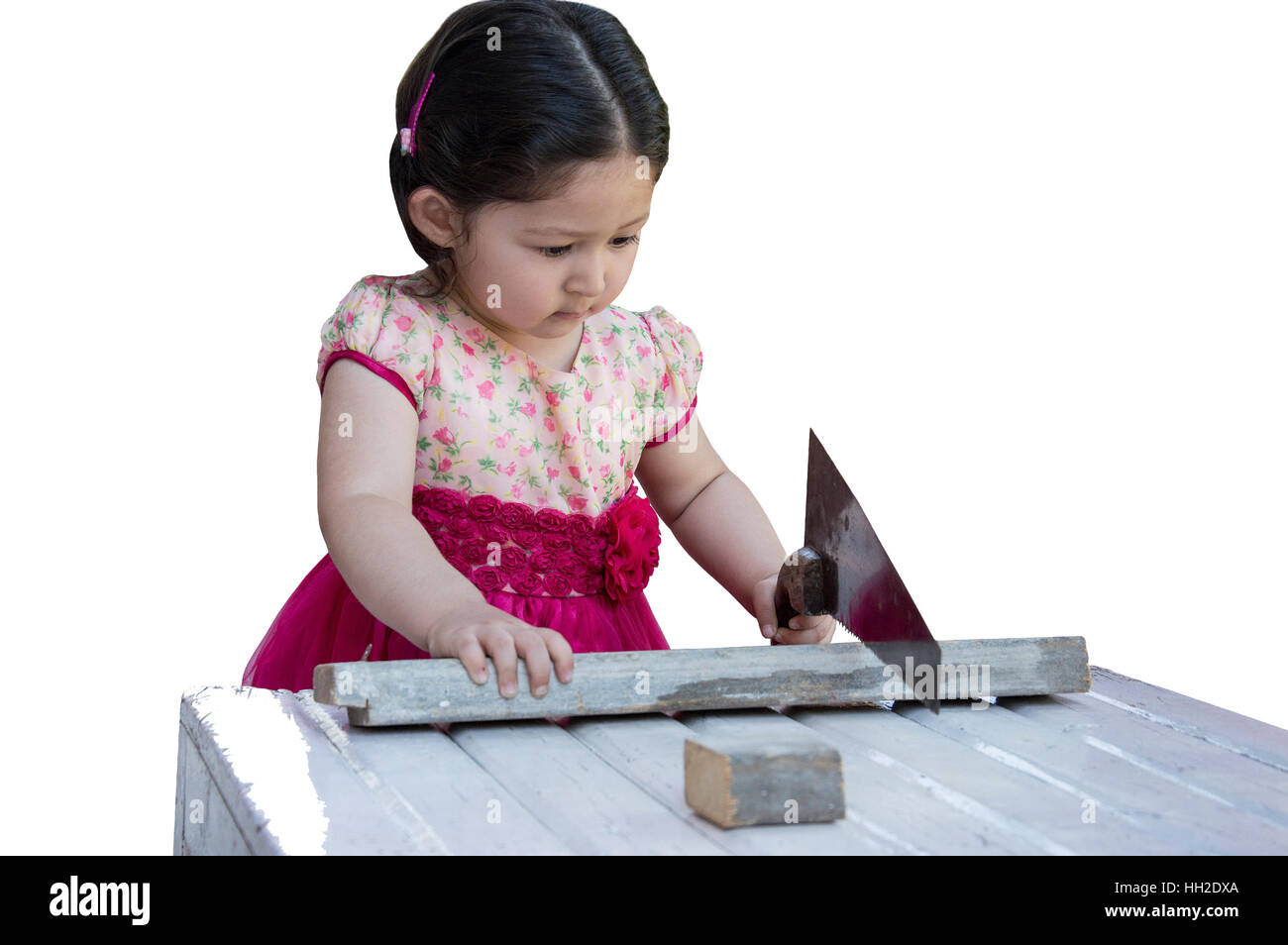 Little girl sawing plank with a handsaw. Isolated on white background. Stock Photo