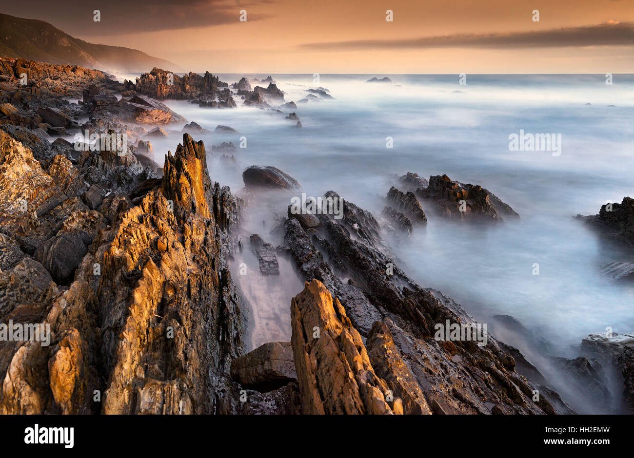 Long exposure of jagged coastal rocks at Storm's River, South Africa Stock Photo