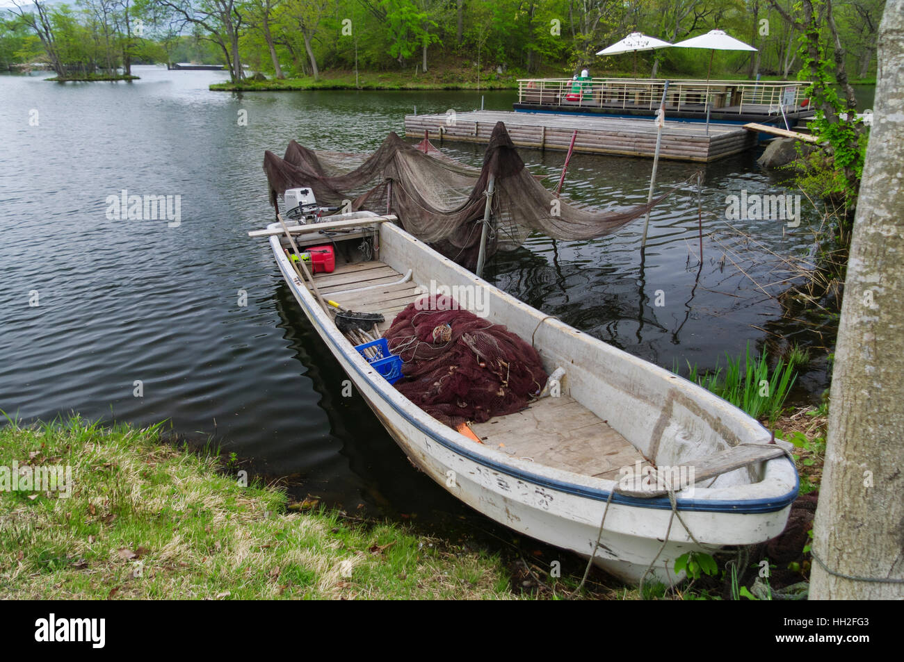 Small fishing boat with nets on the shore of lake Onuma, Hokkaido, Japan. Stock Photo