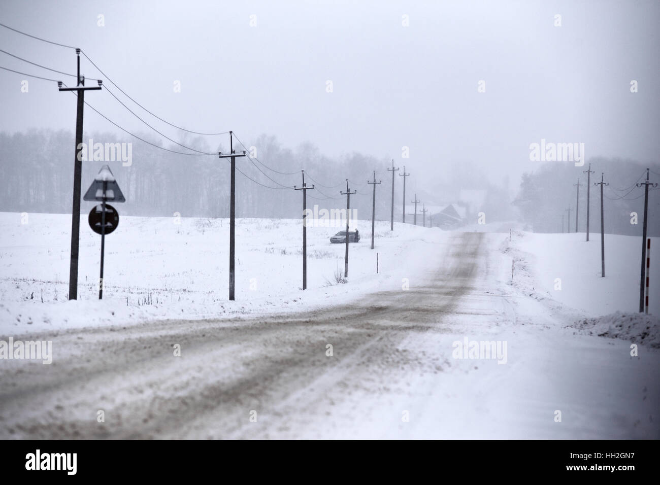 Snowfall and sleet on winter road. Ice snowy road. Winter snowstorm