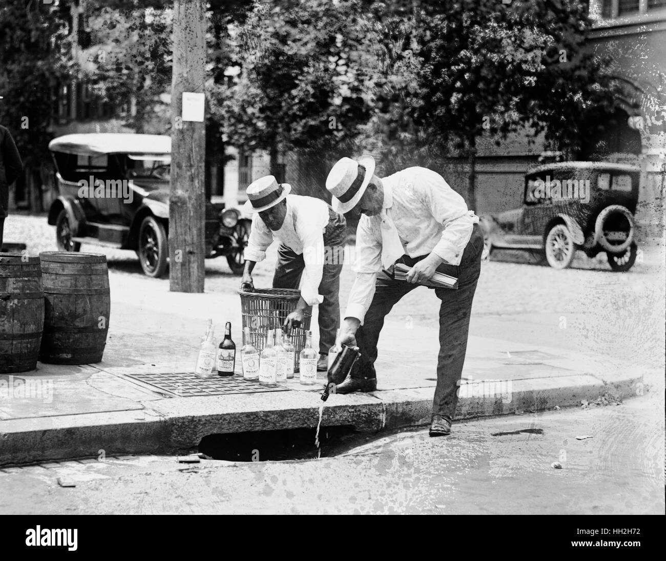 Pouring whiskey into a sewer during Prohibition. Stock Photo