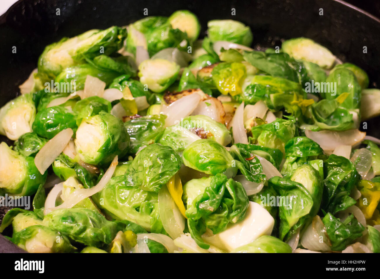 Brussel sprouts being cooked in a skillet with real butter in a home kitchen. Stock Photo
