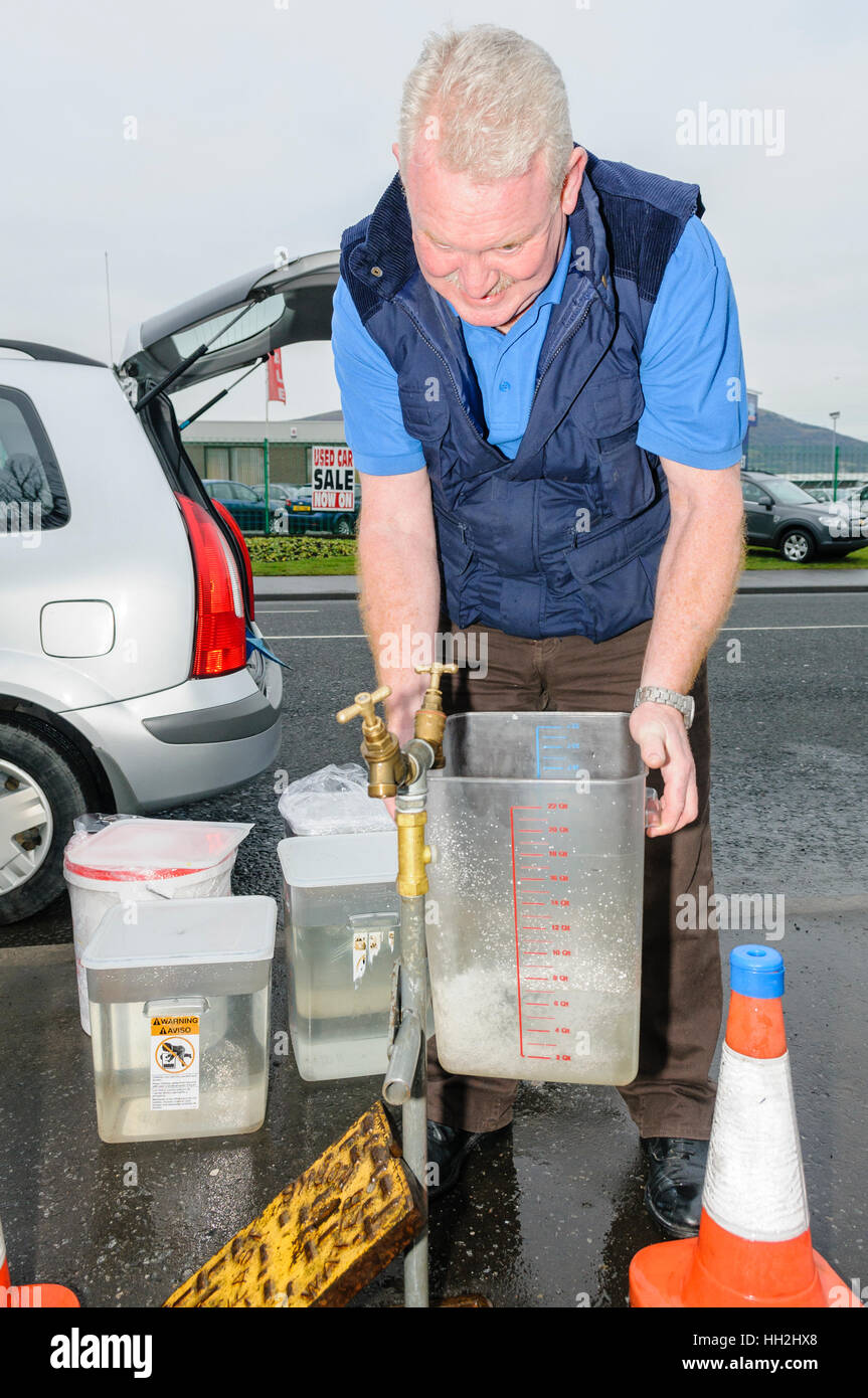 Belfast, Northern Ireland. 28 Dec 2010 - A member  of the public uses an emergency standpipe to fill a container following a major water shortage in Northern Ireland Stock Photo