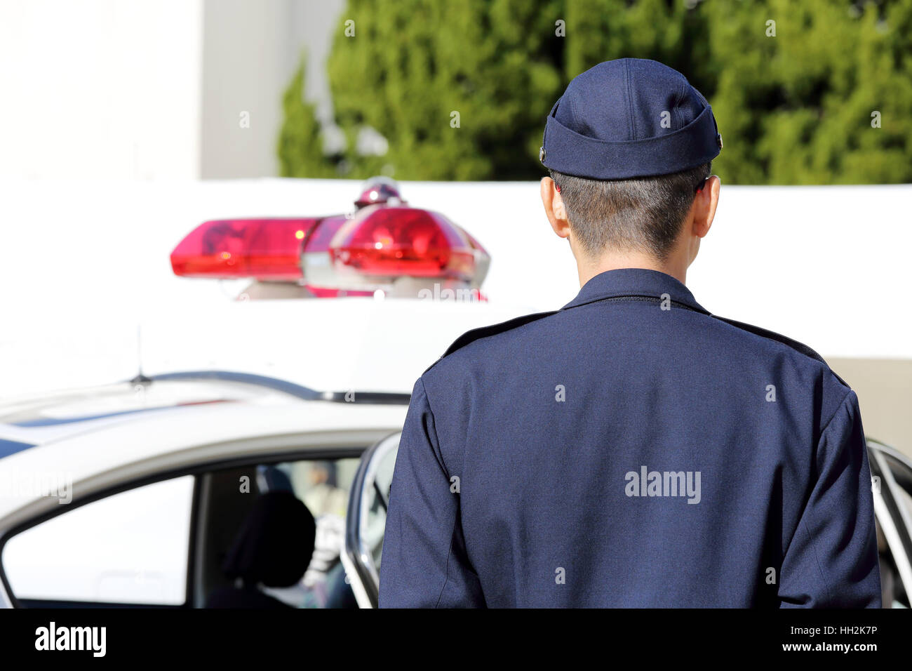 Back view of Japanese police officer with patrol car Stock Photo