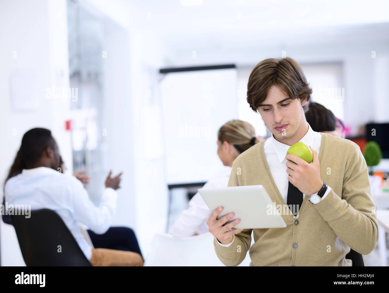 Portrait of confident businessman using digital tablet while colleague in background Stock Photo