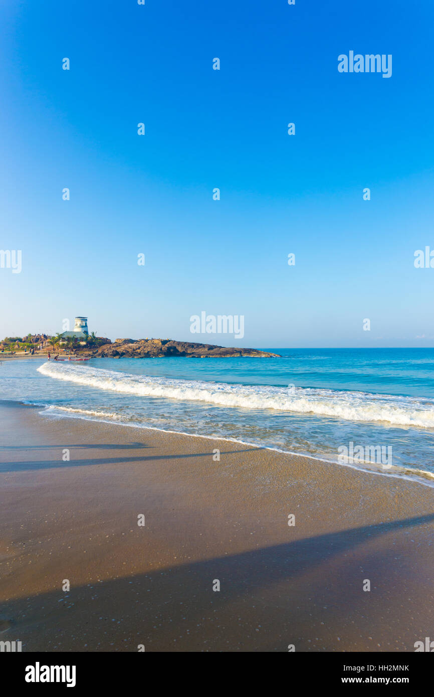 The life guard aid post resembling a stubby lighthouse sits atop a rocky outcrop on the tourist town of Kovalam Beach Stock Photo