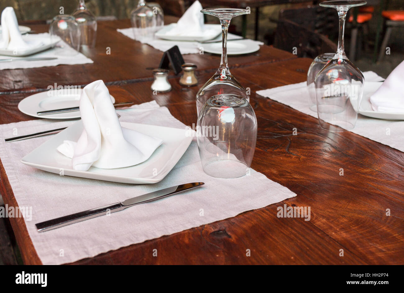 Restaurant table set with glasses, napkins and forks Stock Photo